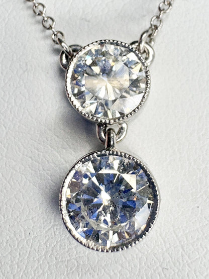 A 14k white gold necklace with two bezel-set natural diamonds.