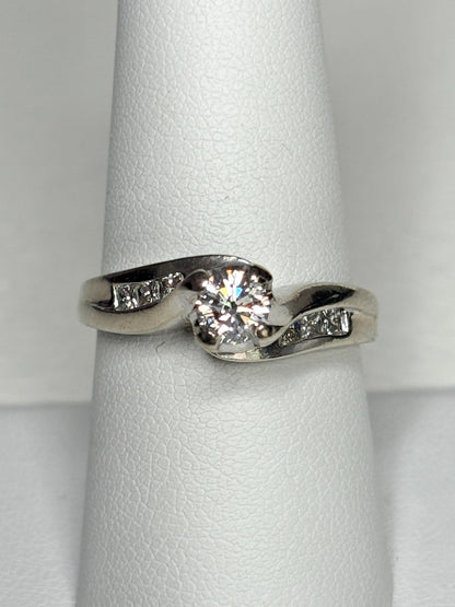 A vintage 14k white gold engagement ring with a central diamond and channel-set side diamonds.
