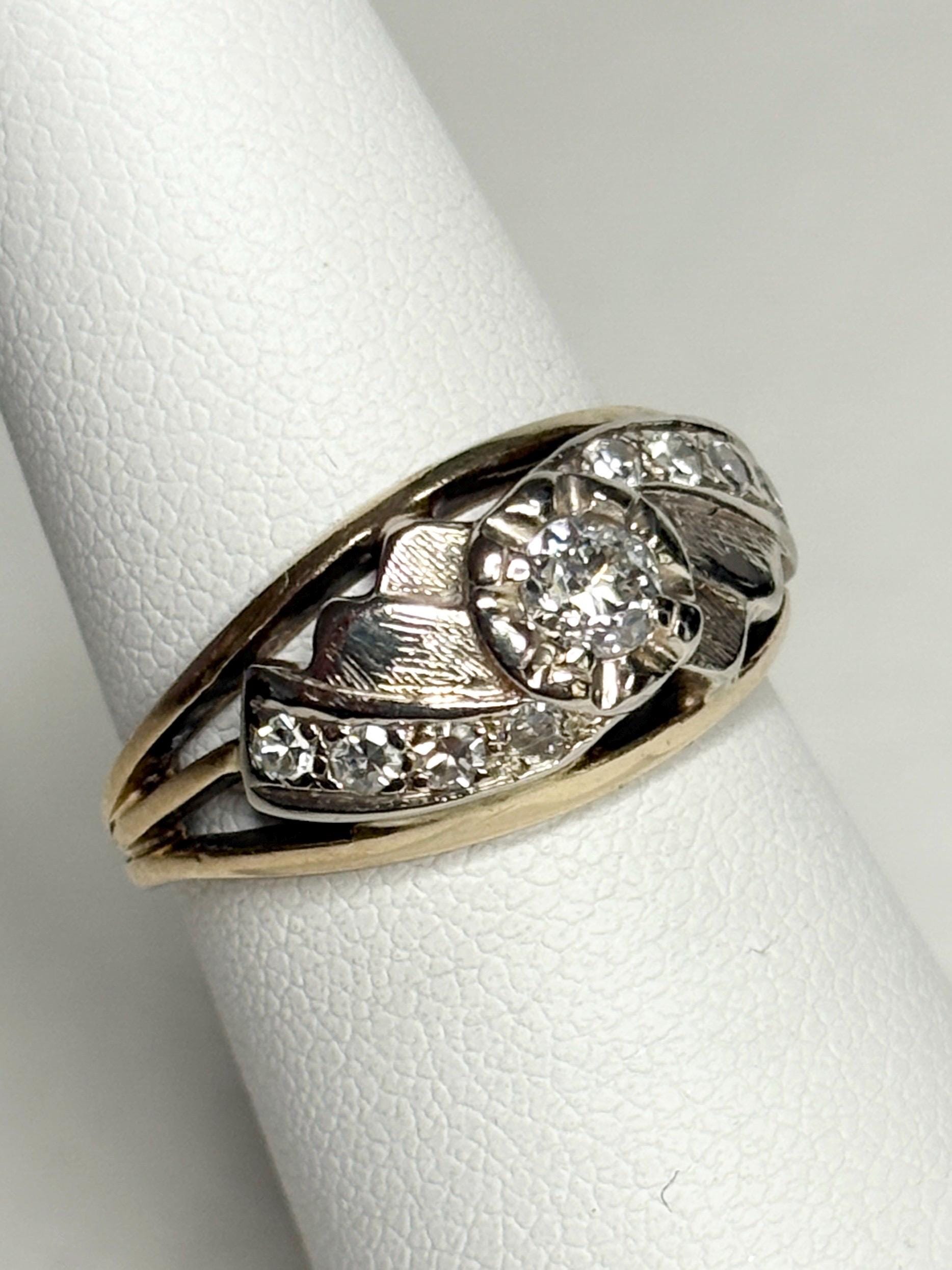 Mid-century two-tone 14k gold ring with a central diamond and smaller accent diamonds.