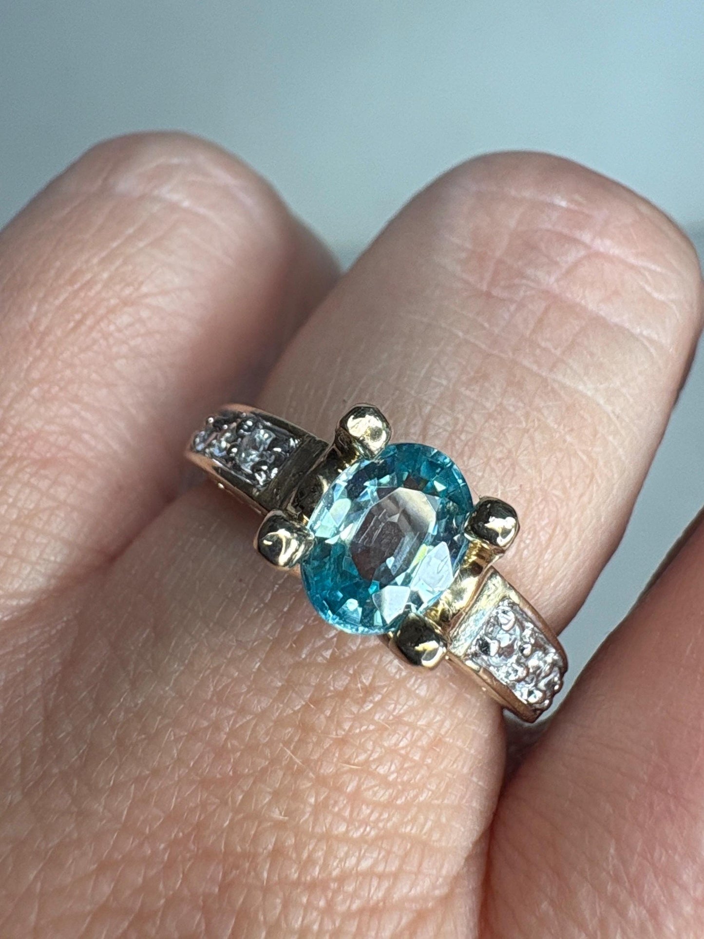 14k gold ring with oval blue zircon and clear side stones.