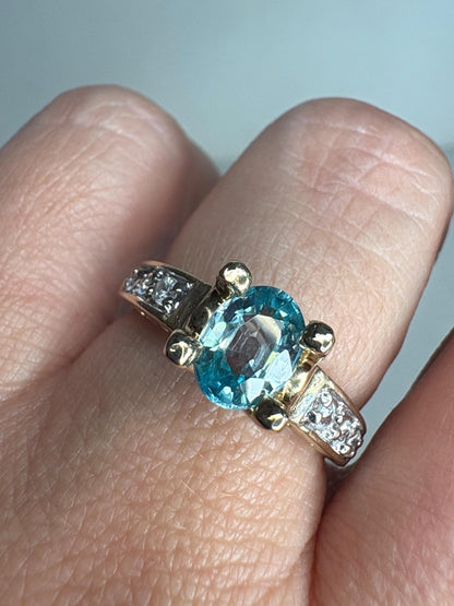 14k gold ring with oval blue zircon and clear side stones.
