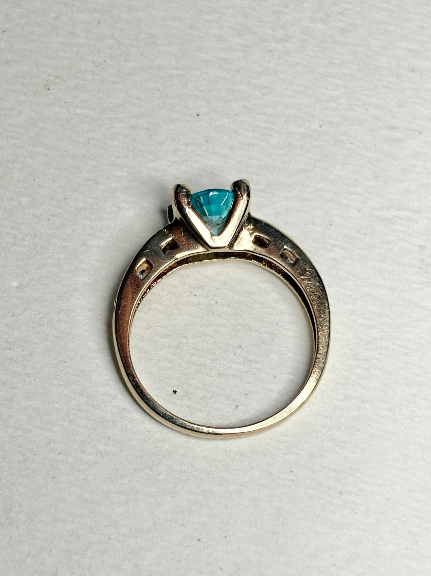 14k gold ring with a blue oval zircon and clear side stones.