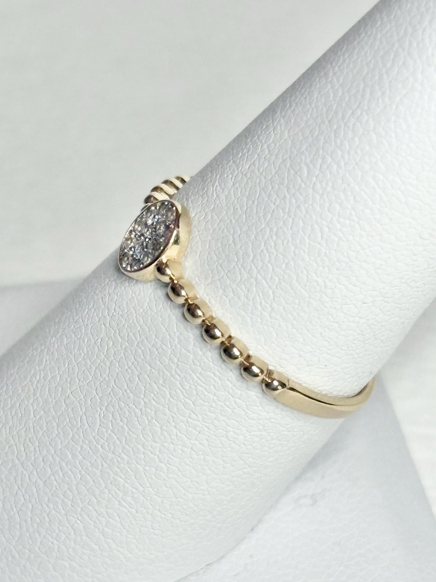Dainty 14k yellow gold ring with a beaded band and an oval pave-set crystal cluster.