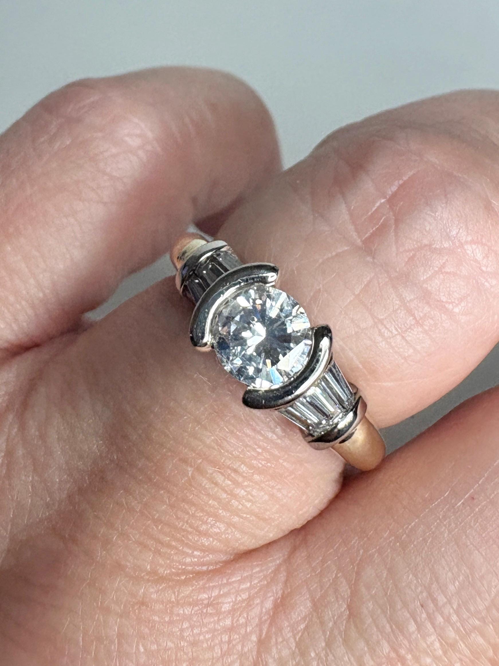 Ring with round diamond, baguette diamonds, and two-tone gold band.