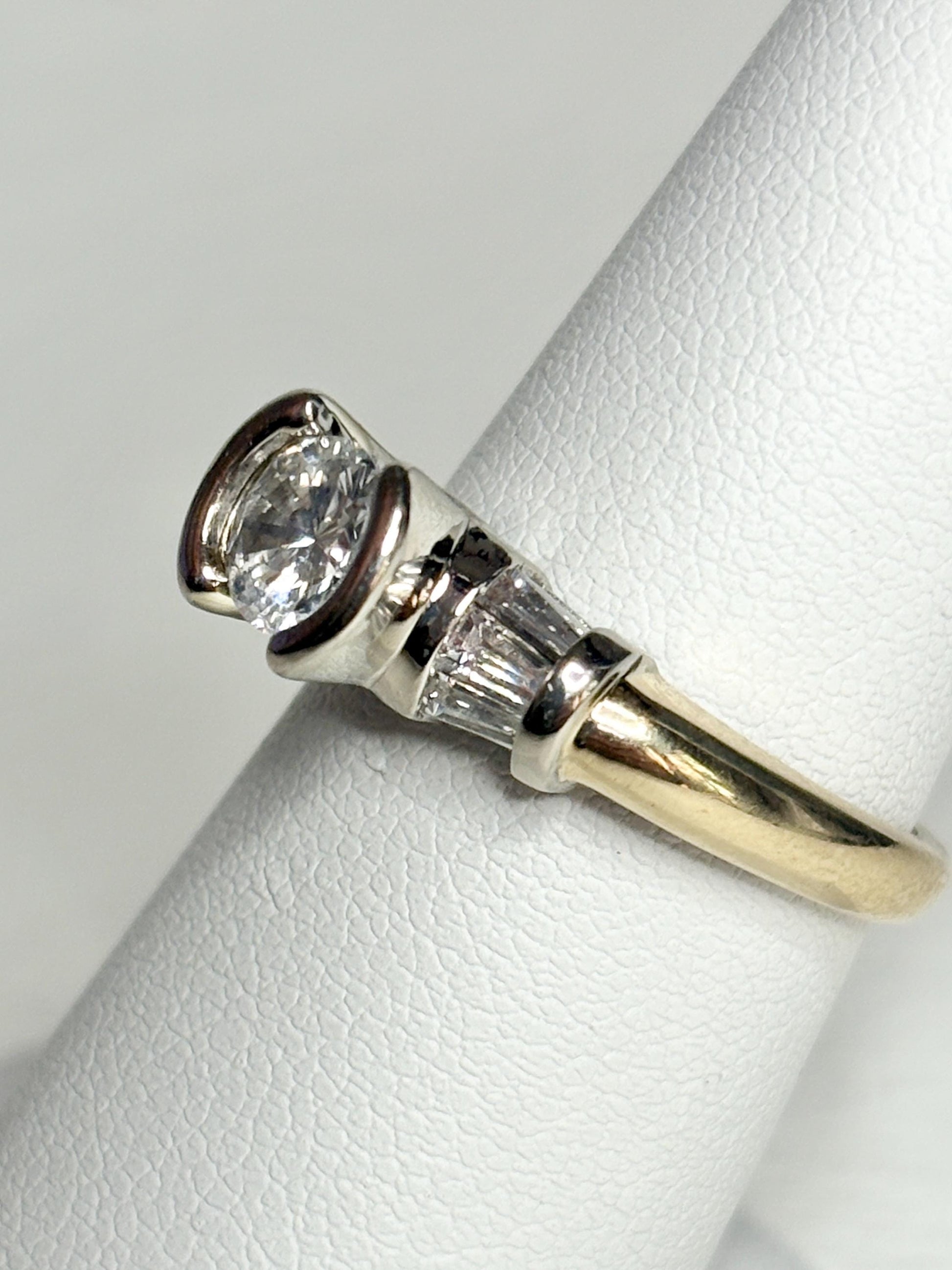 Two-tone 14k gold ring with a round diamond and baguette diamonds.
