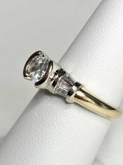 Two-tone 14k gold ring with a round diamond and baguette diamonds.