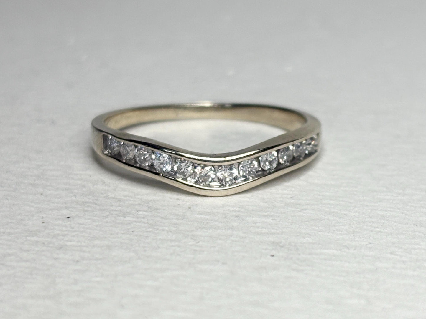 Contoured 14k white gold wedding band with channel-set diamonds.