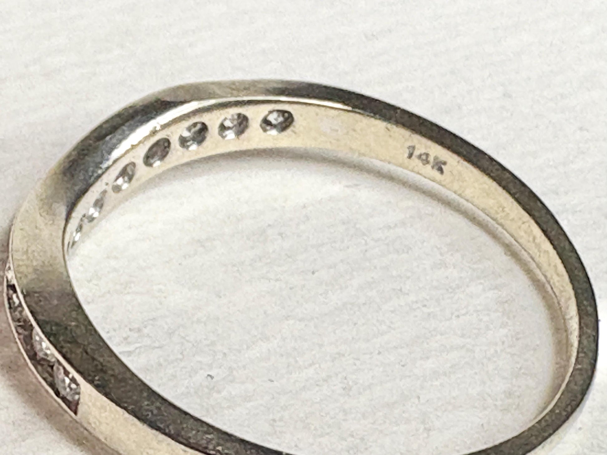 Contoured 14k white gold wedding band with channel-set diamonds.