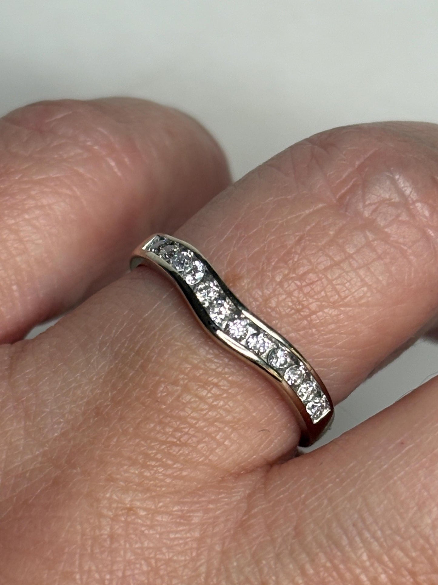 Contoured 14k white gold wedding band with channel-set diamonds.