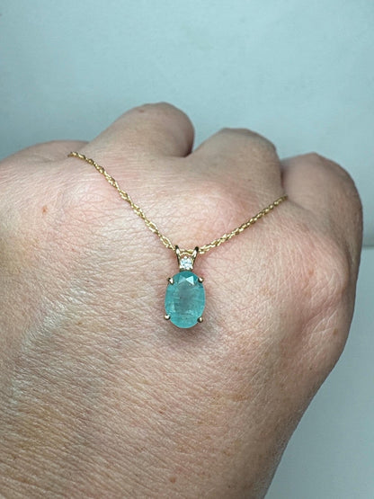 14k gold necklace with an oval grandidierite and diamond pendant.