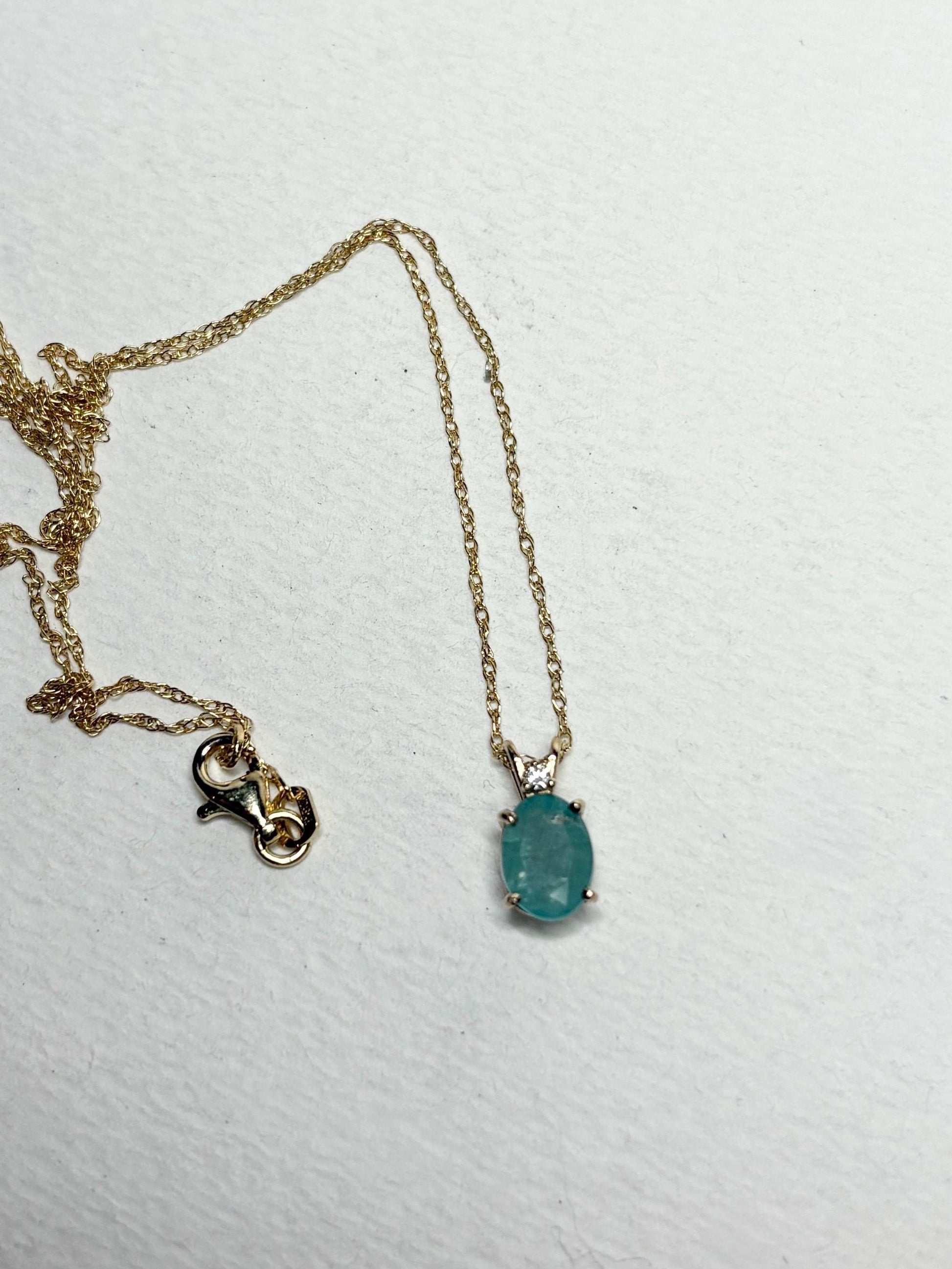 14k gold necklace with an oval grandidierite and diamond pendant.