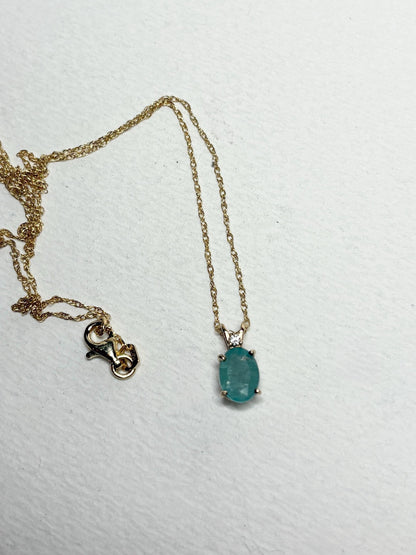 14k gold necklace with an oval grandidierite and diamond pendant.