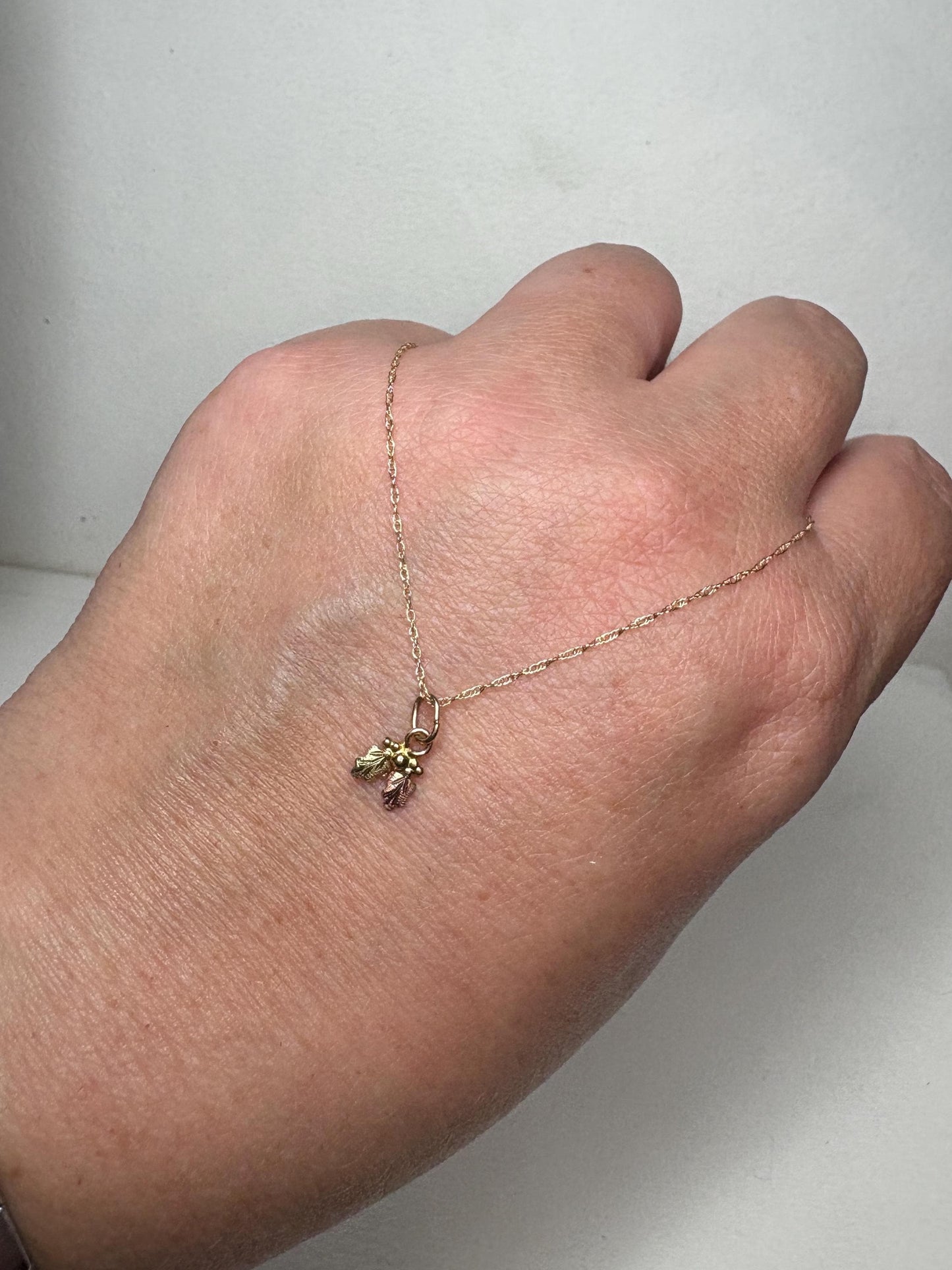 Dainty Black Hills Gold pendant necklace with leaves and berries on an 18-inch chain.