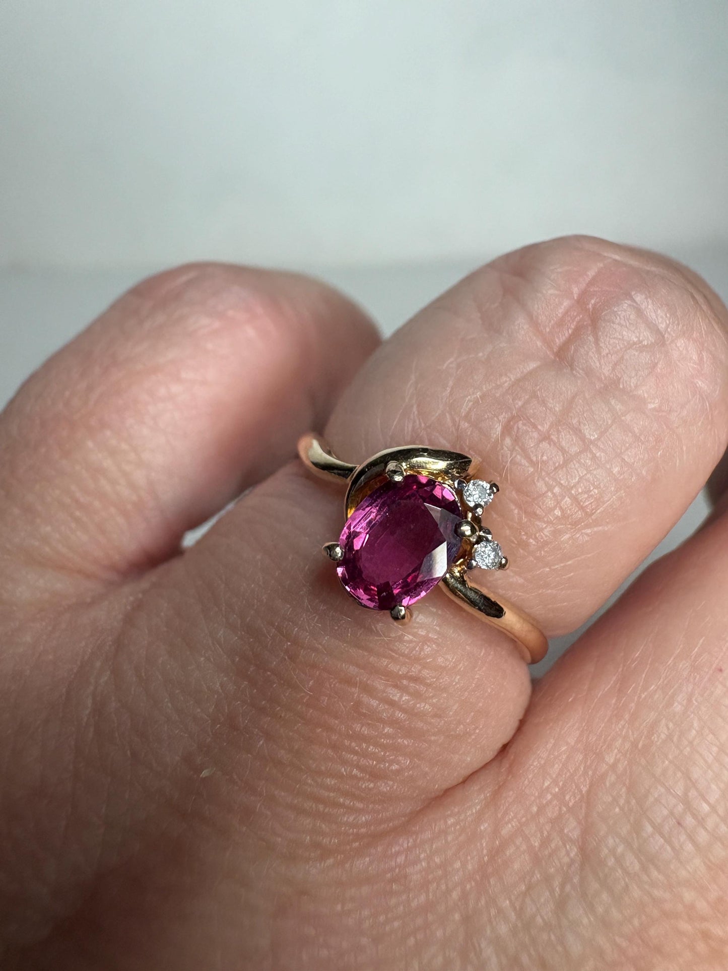 A pink sapphire and diamond ring in 14k gold.