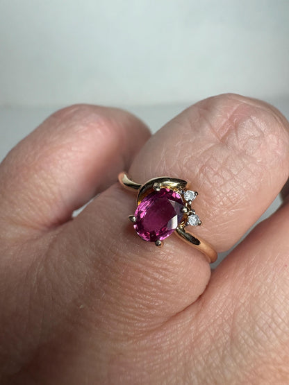 A pink sapphire and diamond ring in 14k gold.