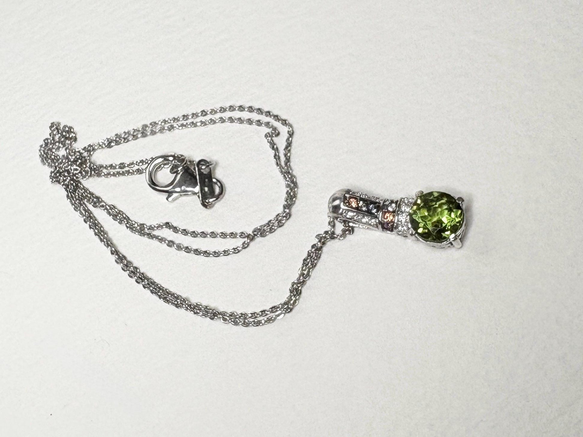 Sterling silver necklace with a simulated diaspore pendant and moissanite and sapphire accents.