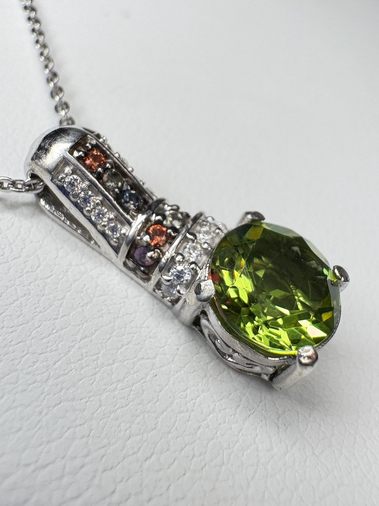 Sterling silver pendant necklace with simulated diaspore, moissanite, and natural sapphires.