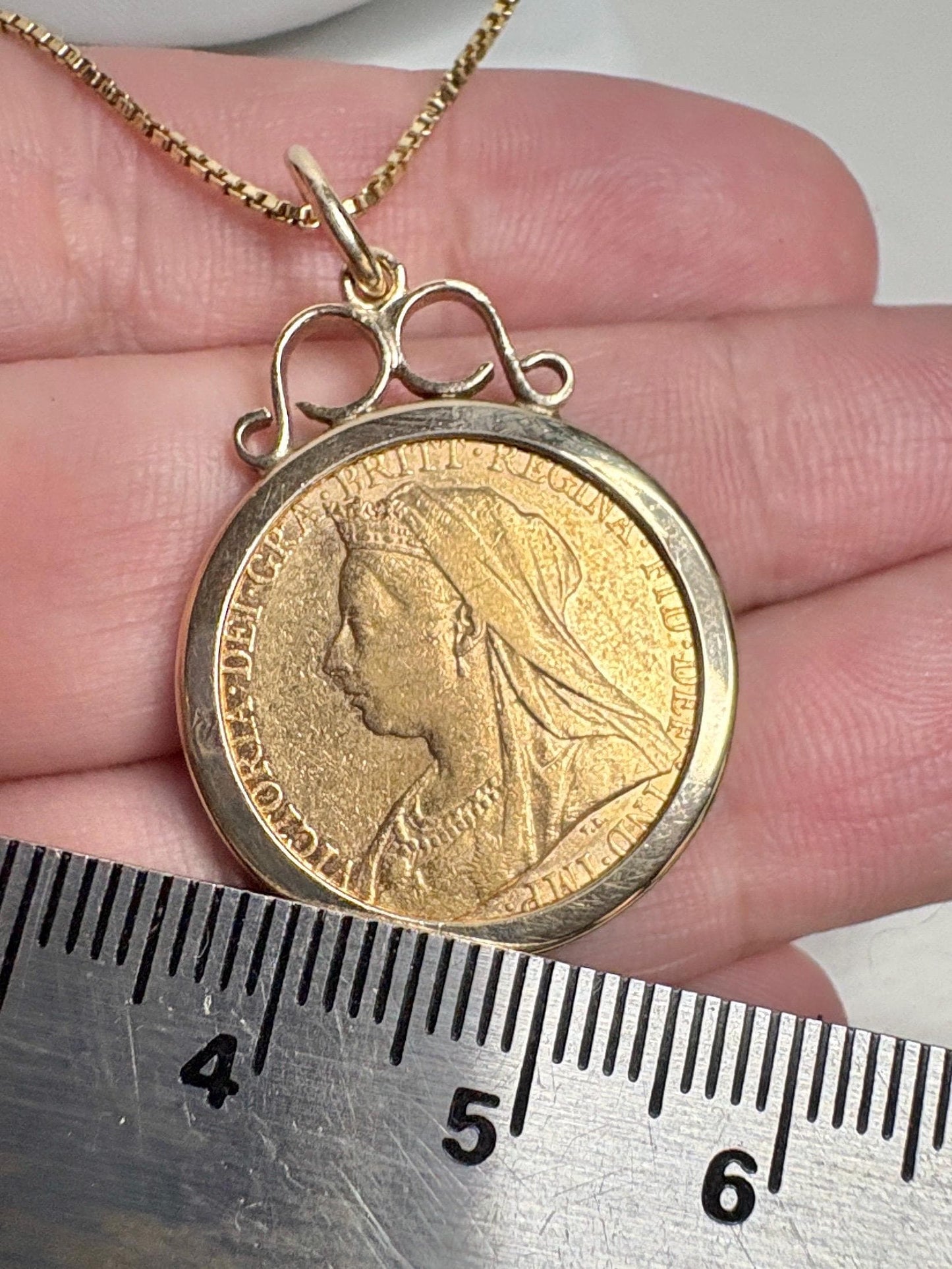 Gold coin pendant with Queen Victoria's profile and a ruler.