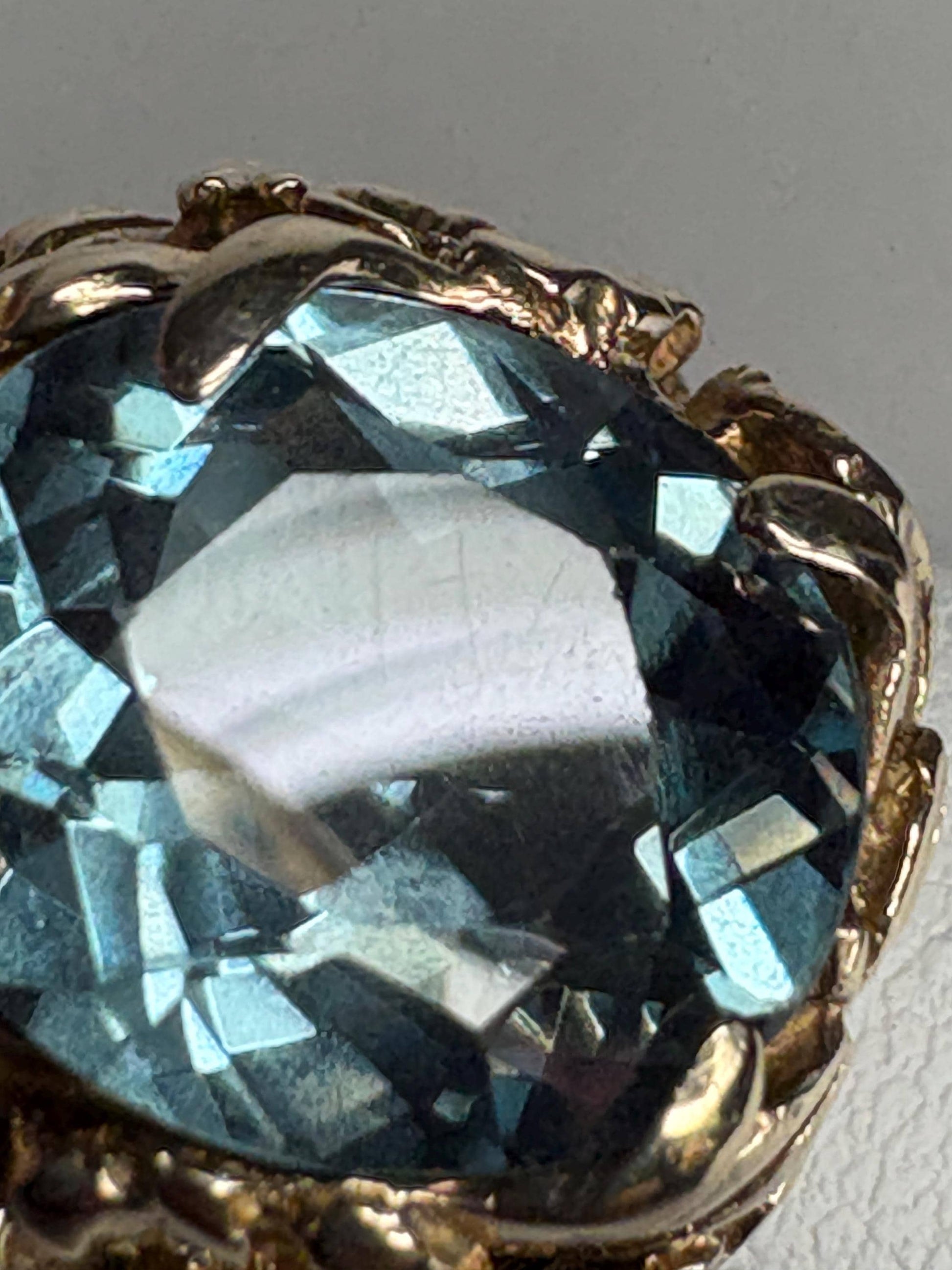 Large mid-century 10k gold ring with a blueish synthetic spinel and floral details.