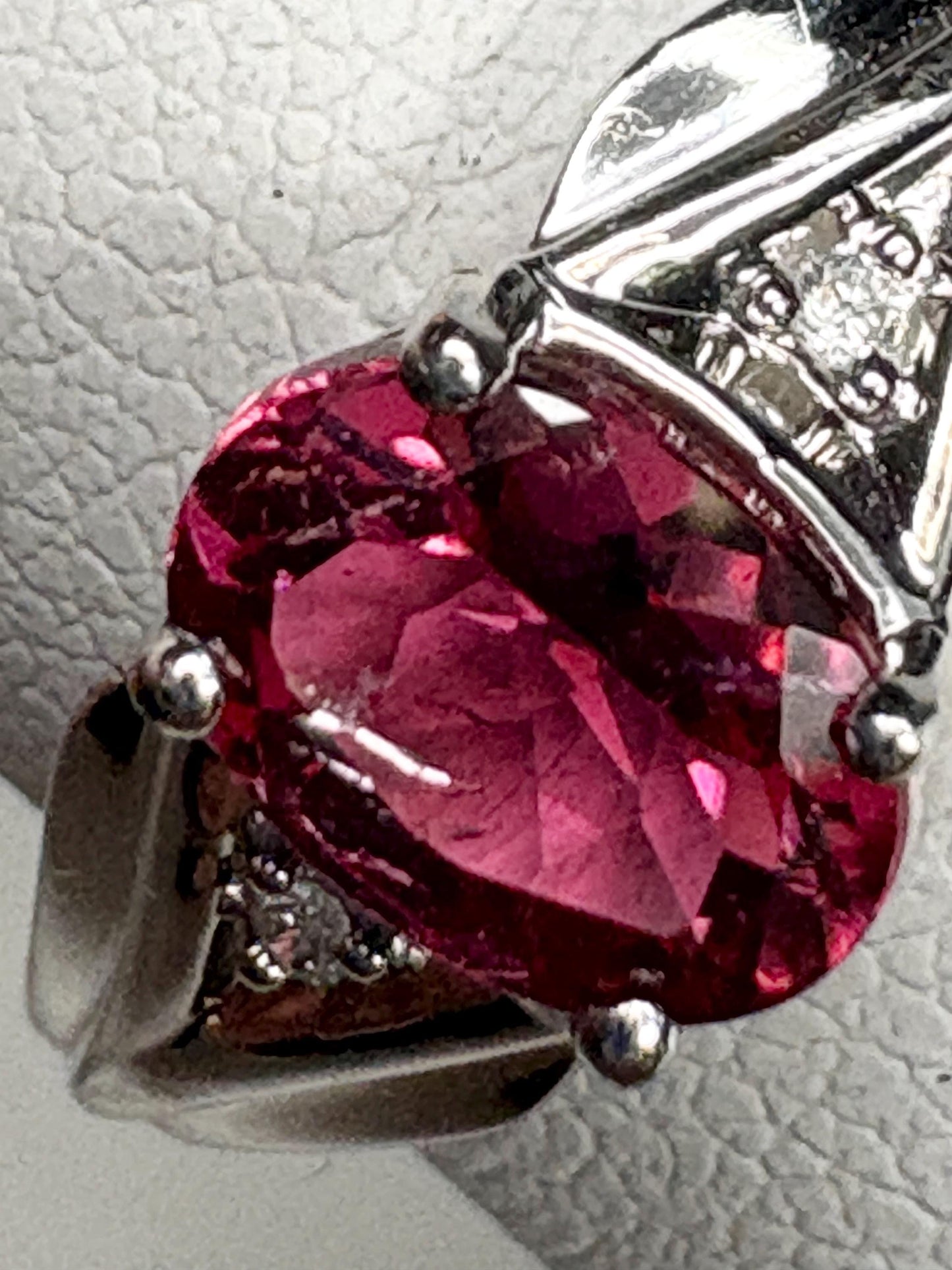 Oval pinkish red rubellite tourmaline and diamond ring in 10k white gold.