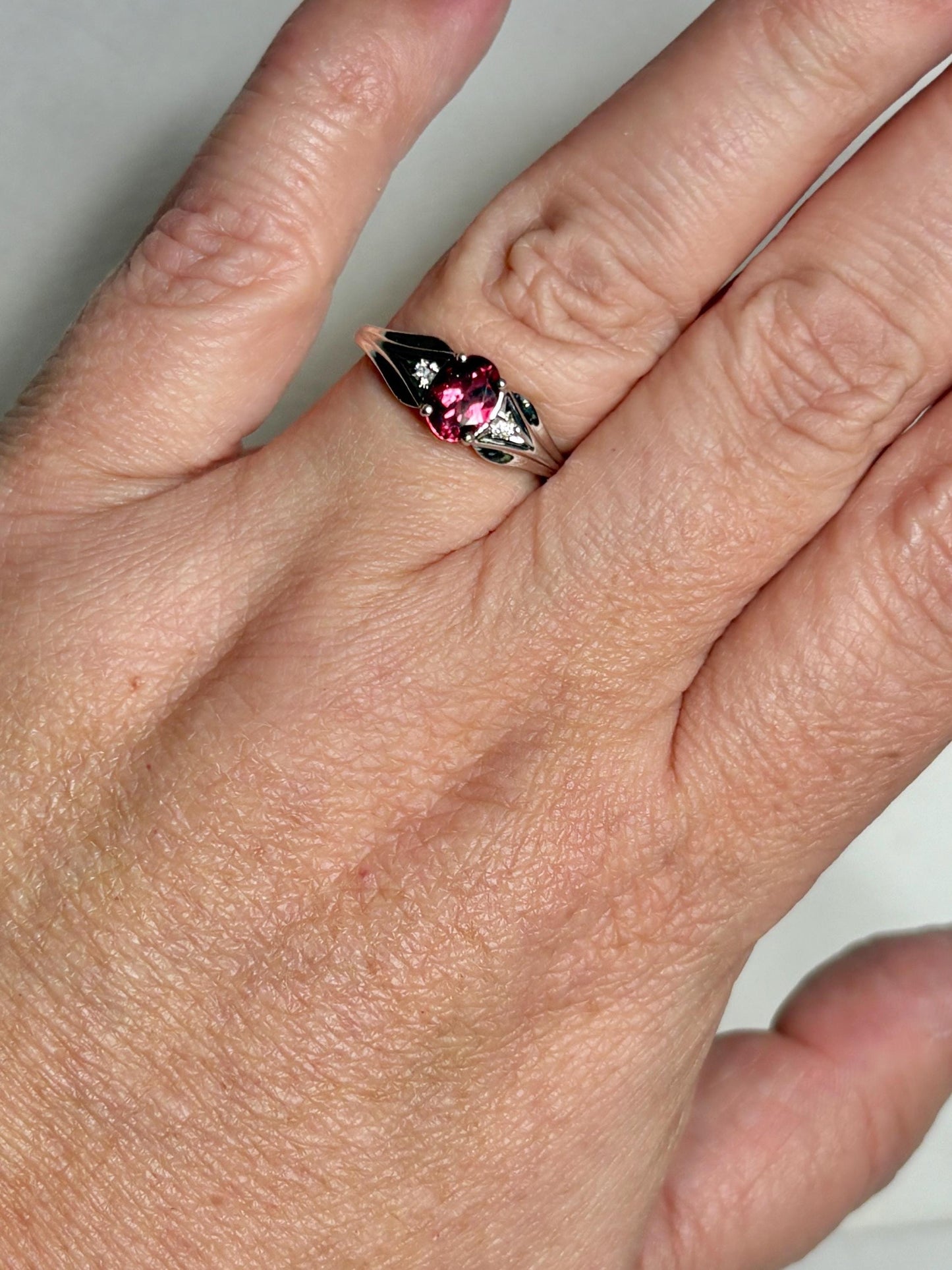 Oval pinkish red rubellite tourmaline and diamond ring in 10k white gold.