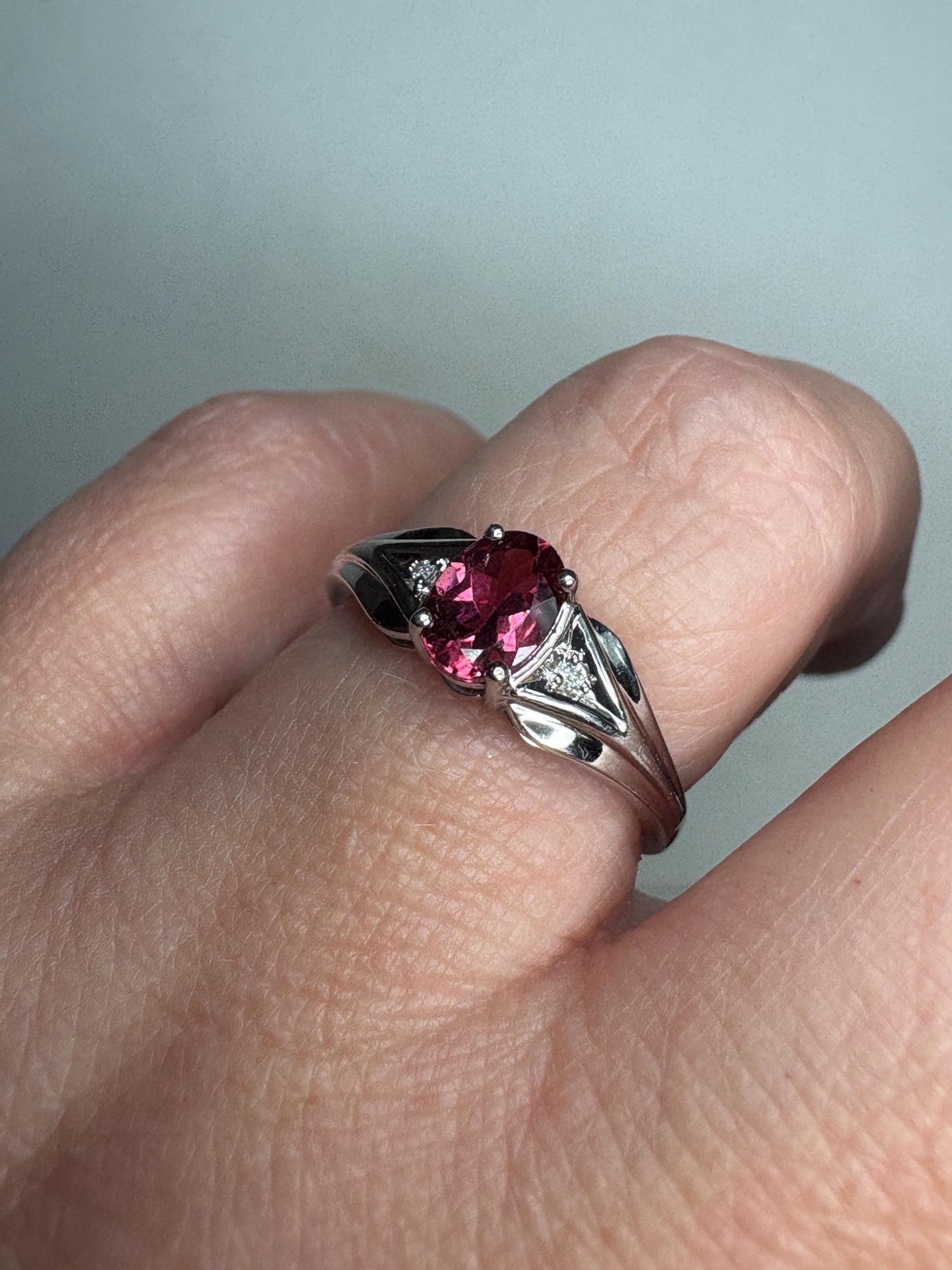 Oval pinkish red rubellite tourmaline and diamond ring in 10k white gold.