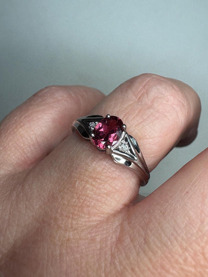 Oval pinkish red rubellite tourmaline and diamond ring in 10k white gold.