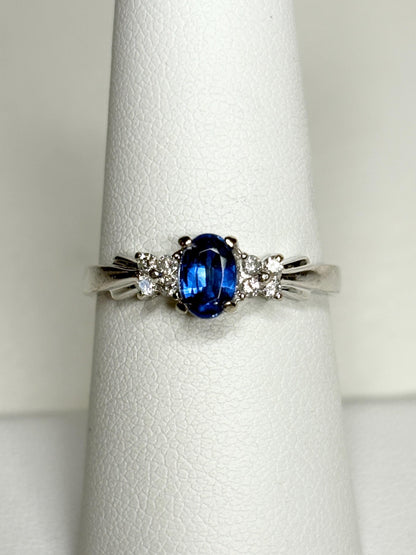 A 10k white gold ring featuring an oval blue kyanite center stone and eight small diamonds.