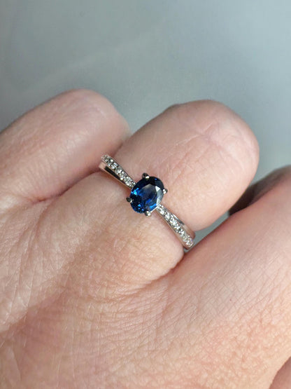A blue sapphire and diamond crossover band ring in 10k gold.