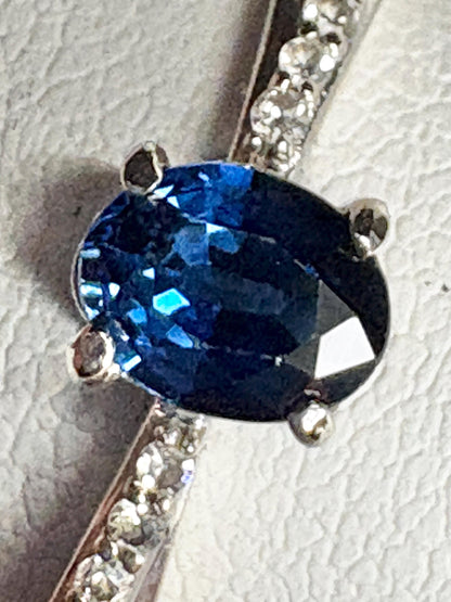 Oval blue sapphire and diamond crossover band ring in 10k gold.