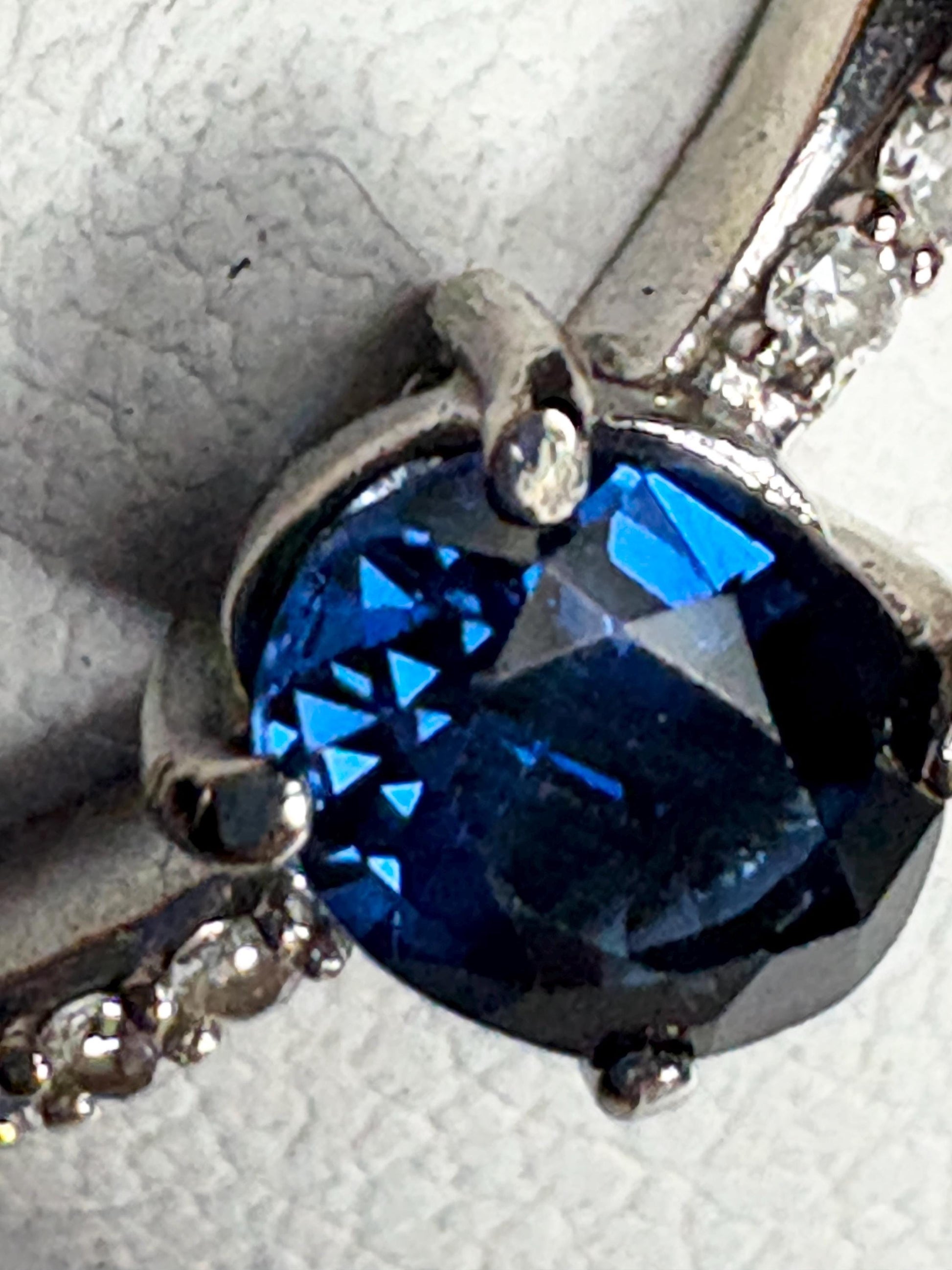 A blue sapphire and diamond crossover band ring in 10k gold.