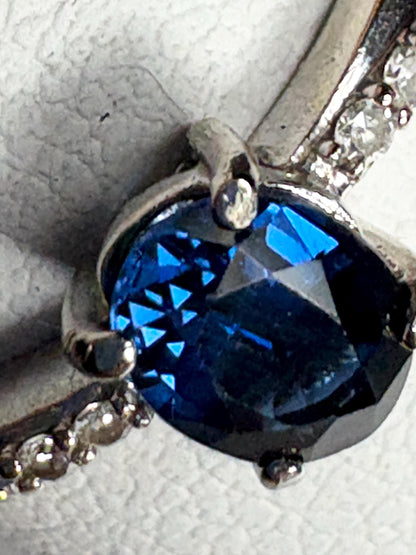 A blue sapphire and diamond crossover band ring in 10k gold.