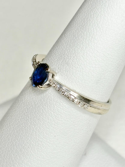 A white gold ring with a blue sapphire and diamonds.