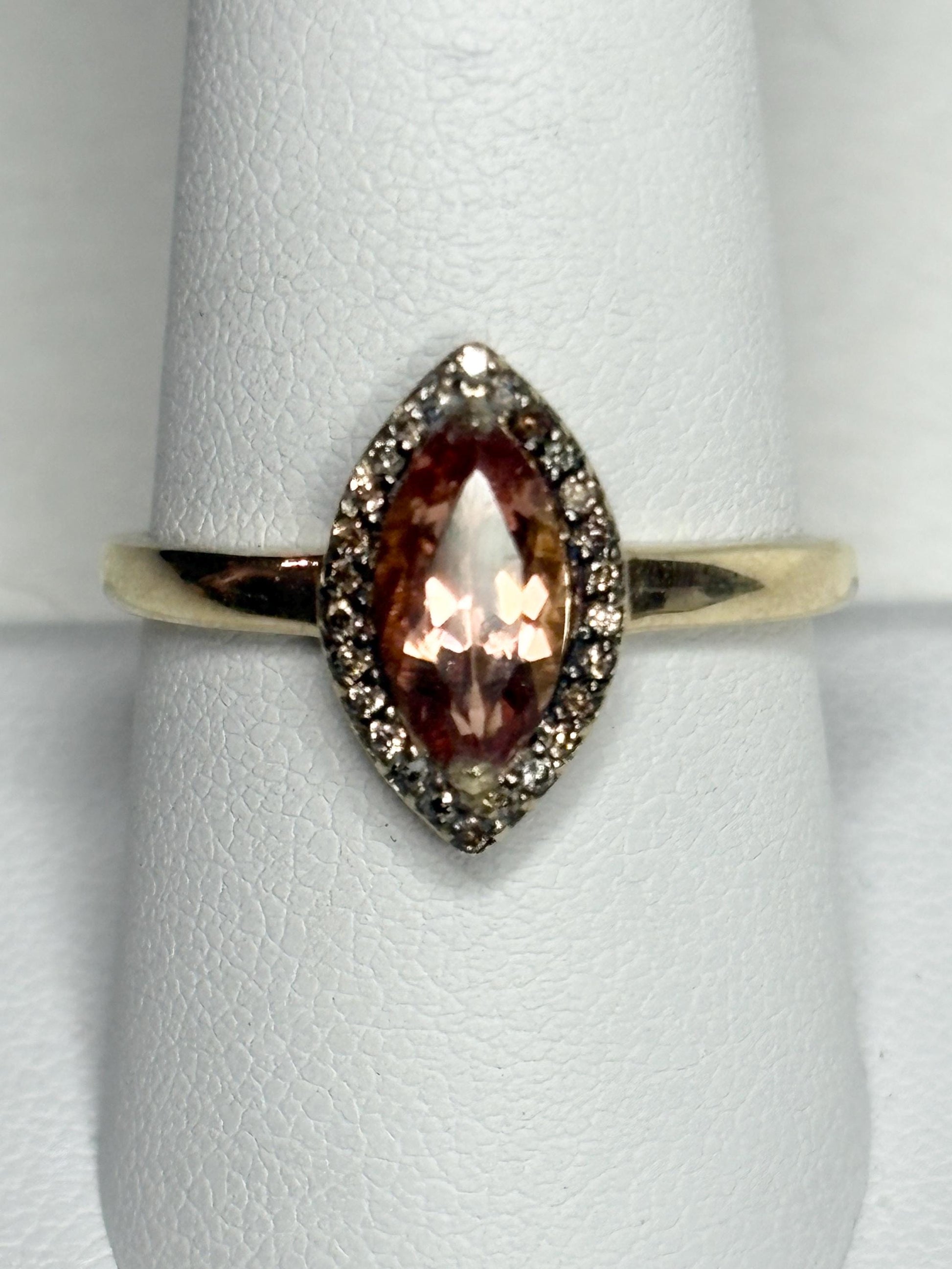 A 10k gold ring with a peach Oregon sunstone and champagne diamonds.