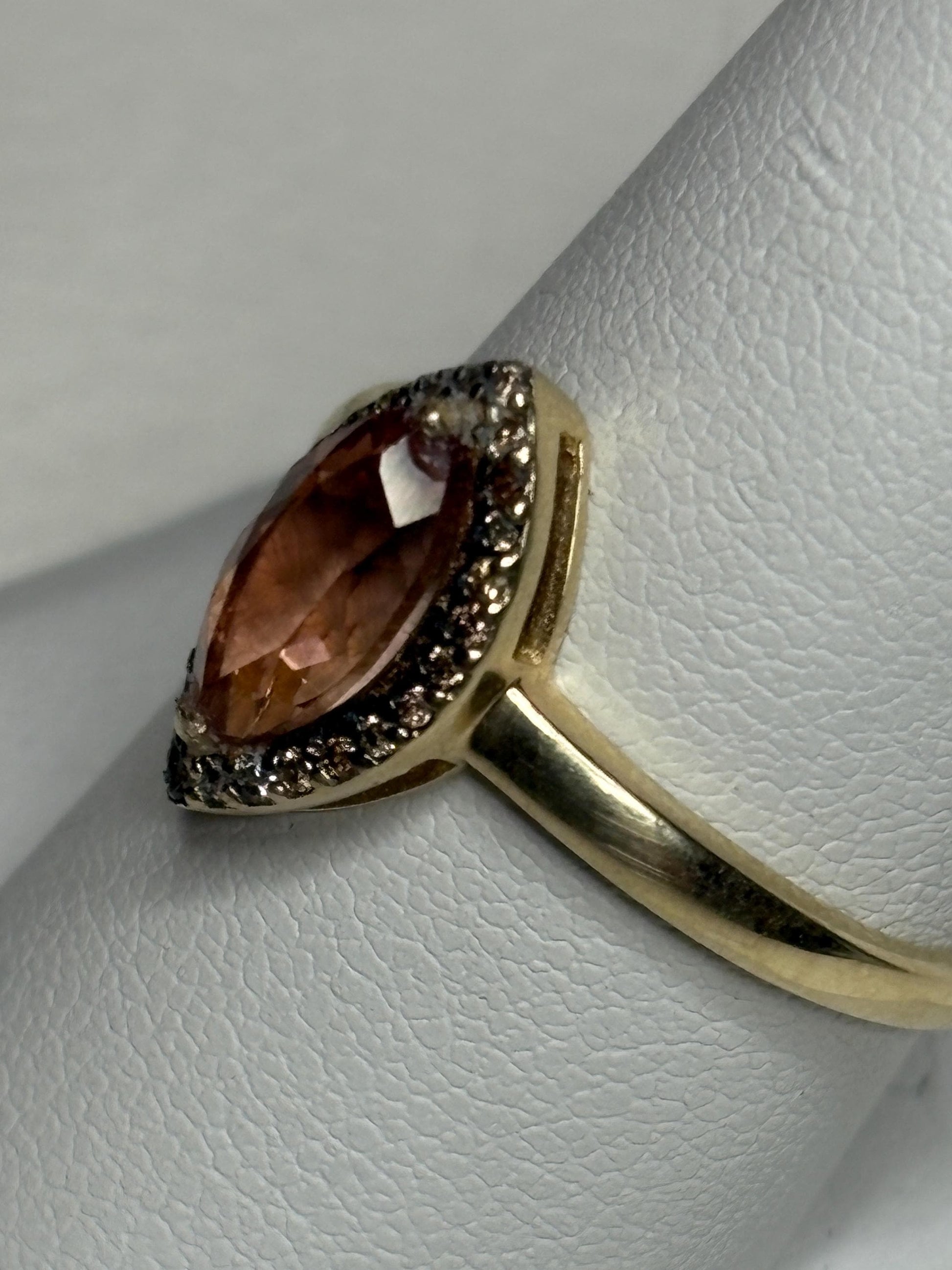 A 10k gold ring with a peach Oregon sunstone and champagne diamonds.