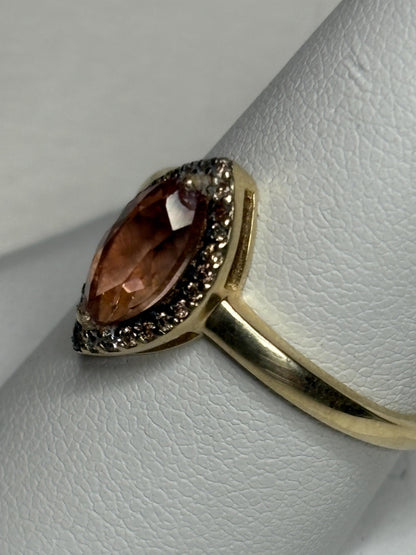 A 10k gold ring with a peach Oregon sunstone and champagne diamonds.