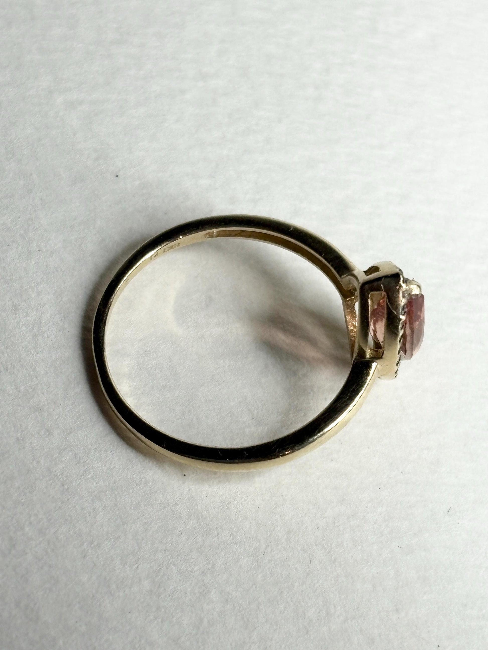 A 10k yellow gold ring with a peach Oregon sunstone and champagne diamonds.