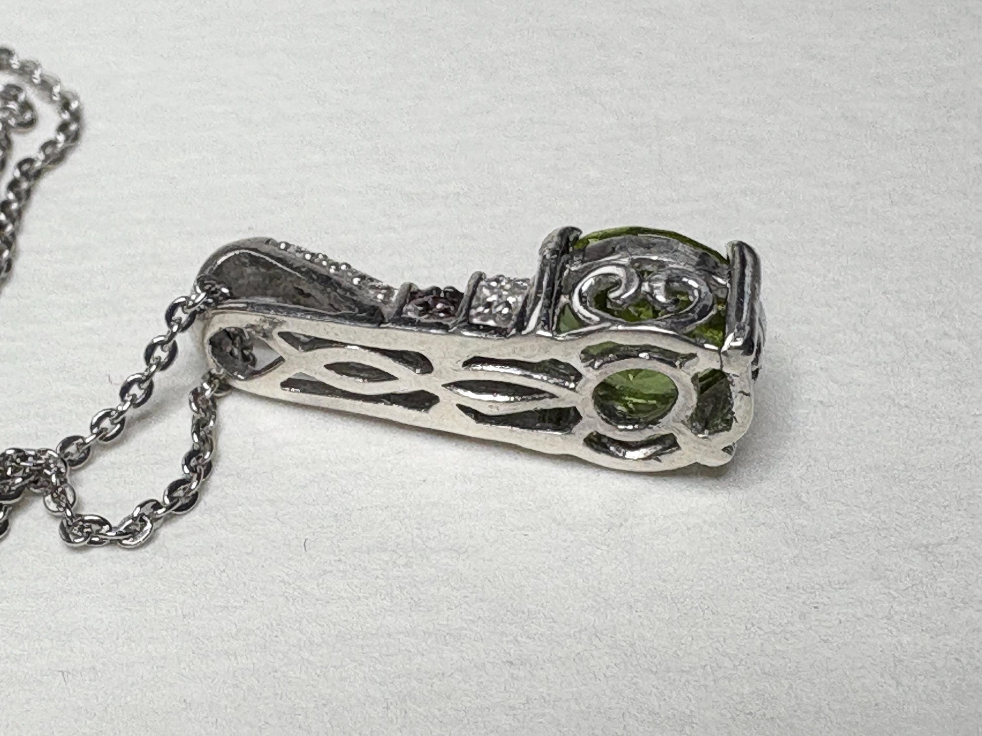 Sterling silver pendant necklace with simulated diaspore, moissanite, and sapphire accents.