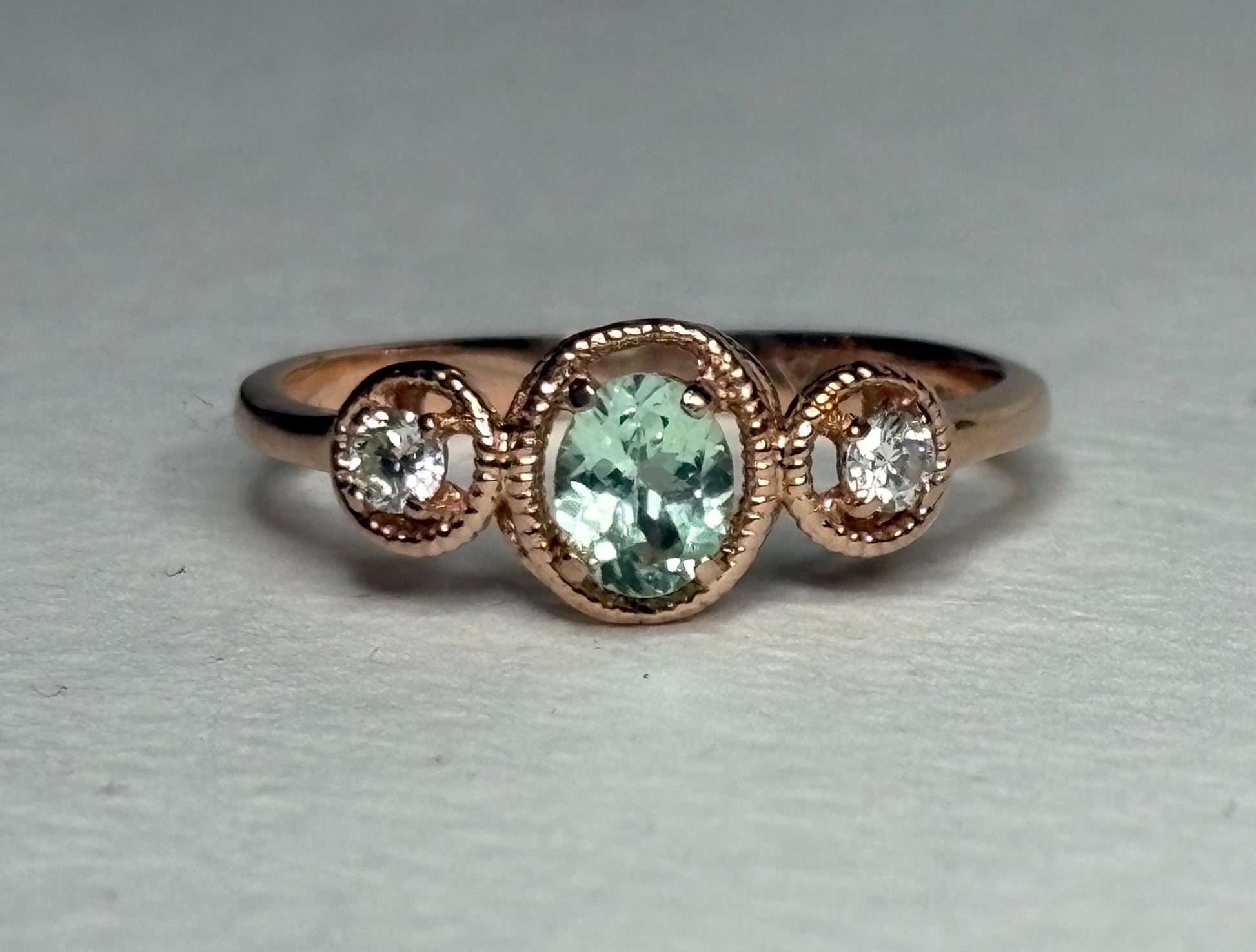 14k rose gold ring with an oval mint green tourmaline and two diamonds.