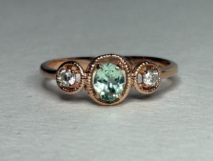 14k rose gold ring with an oval mint green tourmaline and two diamonds.