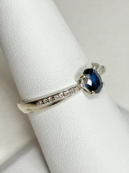 A white gold ring with a blue sapphire and diamonds.