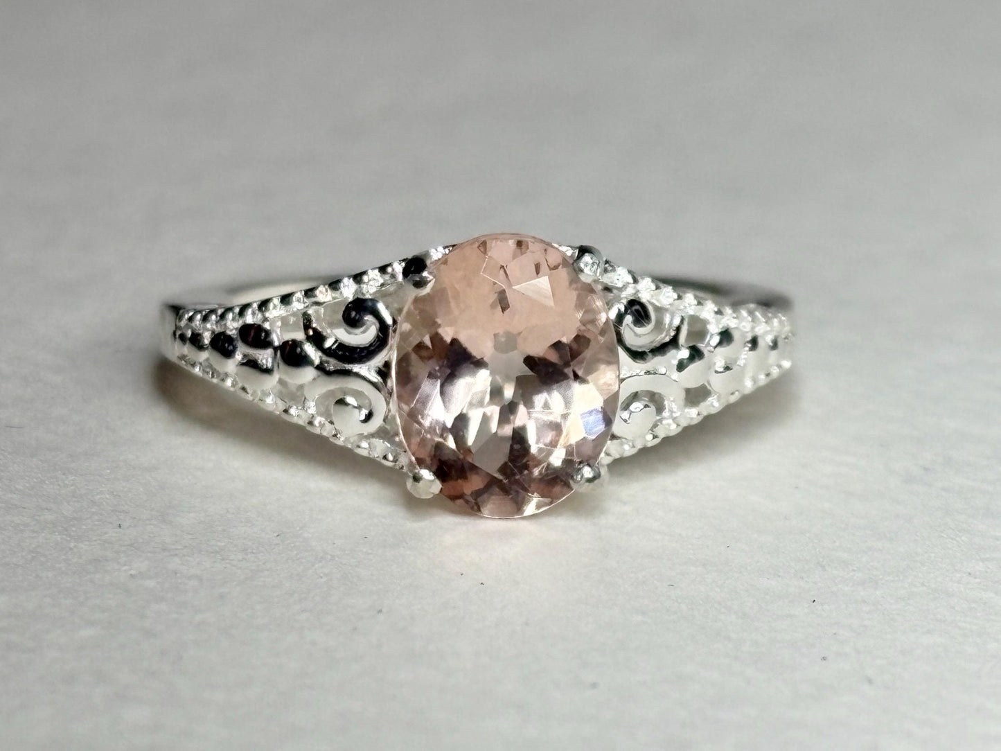 Sterling silver ring with an oval pink morganite and ornate detailing.
